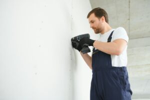 drywall worker works on building site in a house.