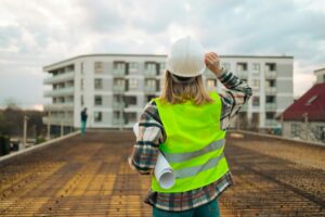 Female construction worker under inspection and checking standing on construction site, working.